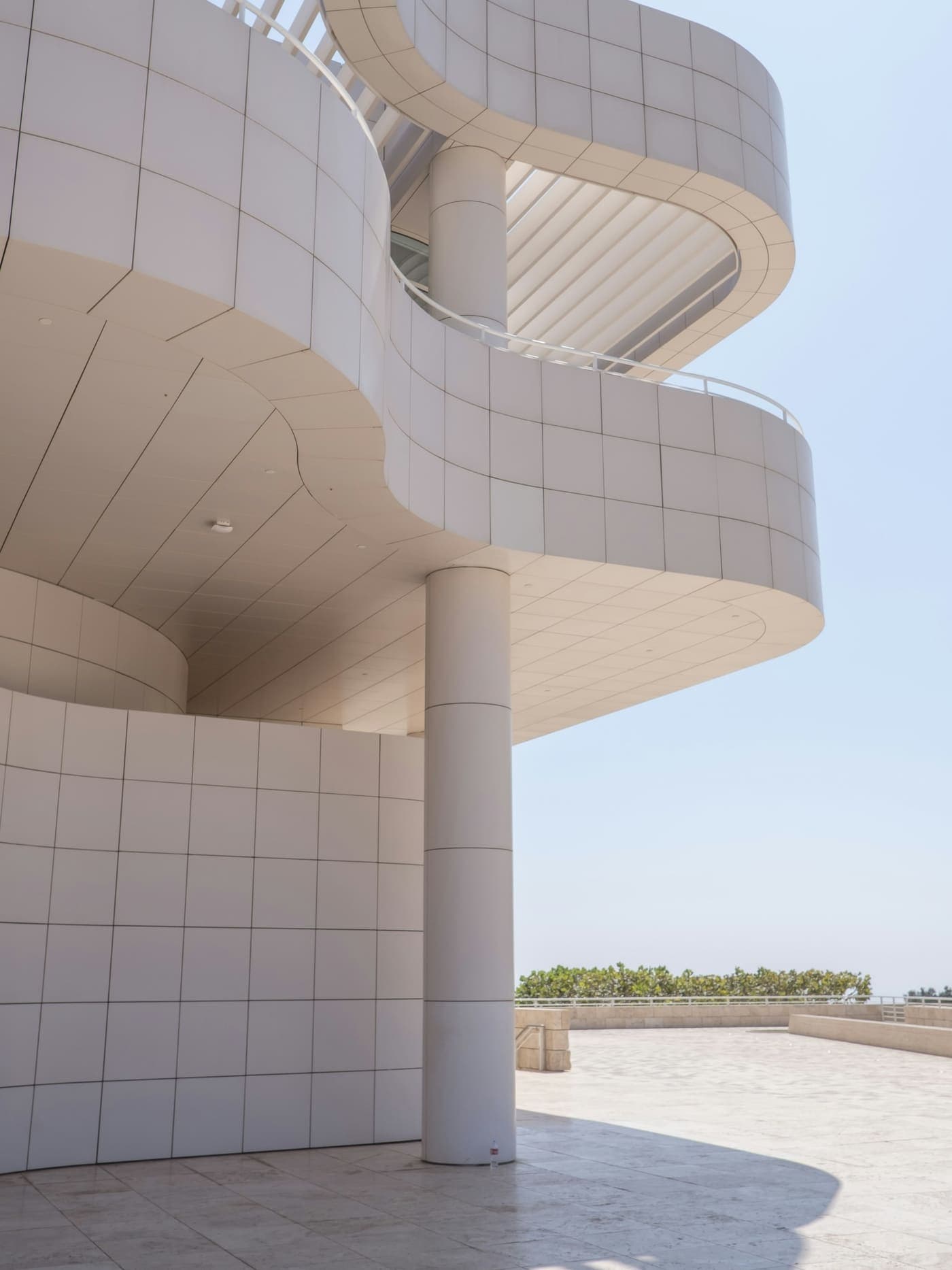 Travertinverkleidete Architektur mit geschwungenen Ebenen im warmen Tageslicht